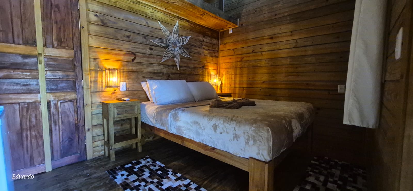 Quarto com cama de casal e decoração rústica